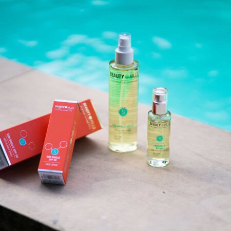Spray solar para rostro y cuerpo frente a una piscina