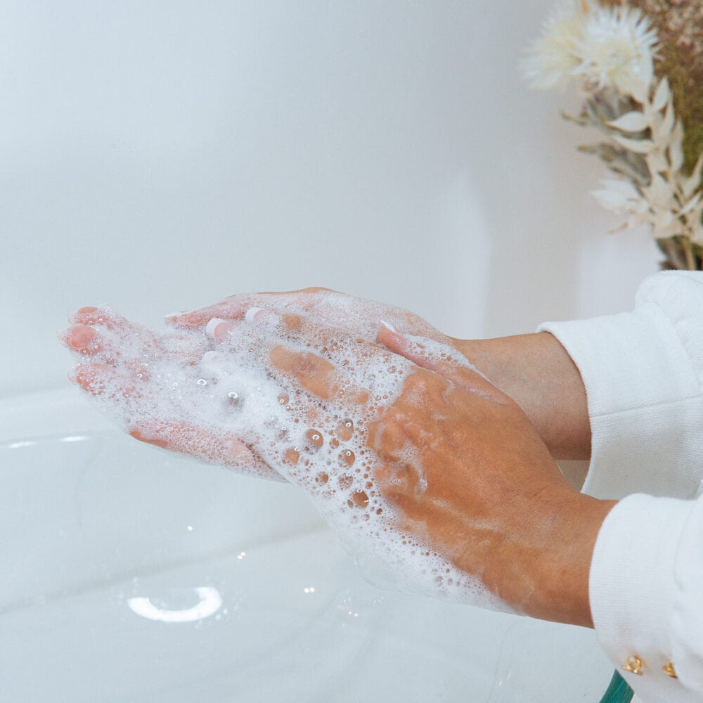 Une femme mousse un gel nettoyant dans ses mains